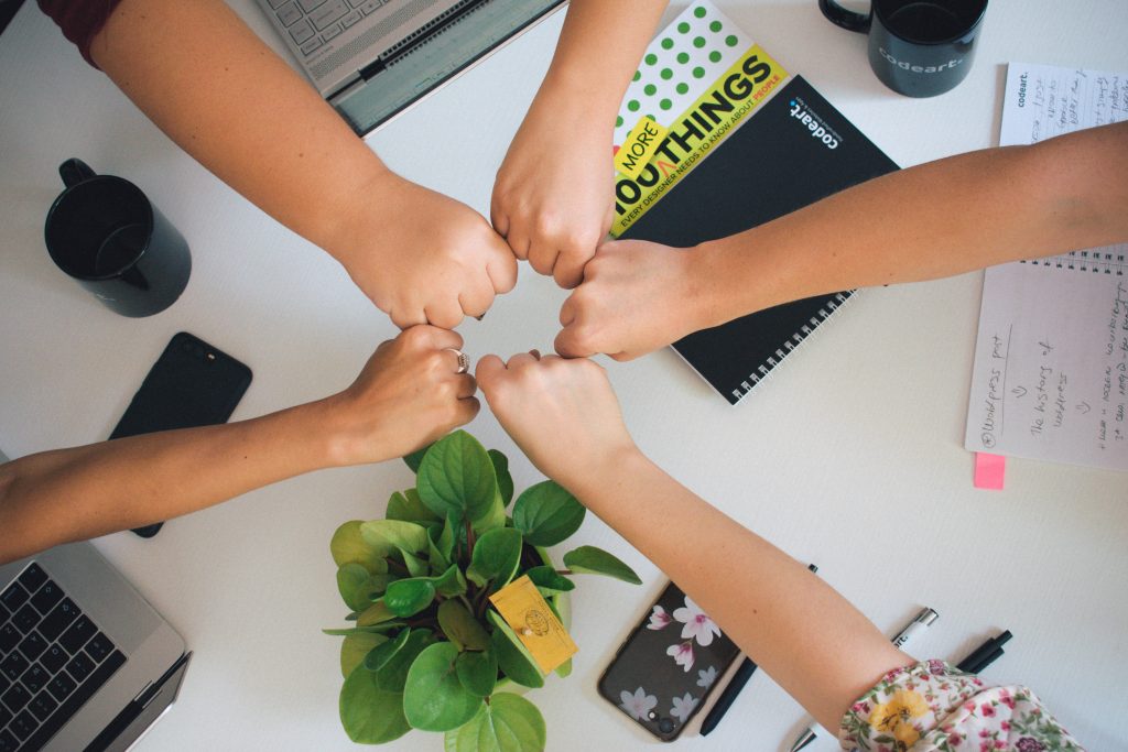 antonio-janeski-CHVTt0aGbx0-unsplash Circle of hands fist-bumping